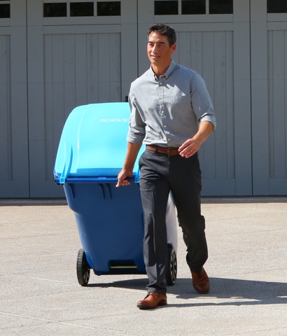 Customer rolling recycle bin in driveway
